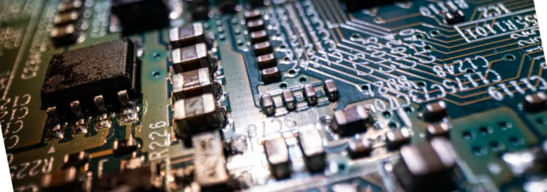 Zelená deska s rezistory a dalšími elektronickými součástkami.