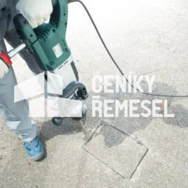 Instalatér pracuje na stavbě s elektrickým kladivem.
