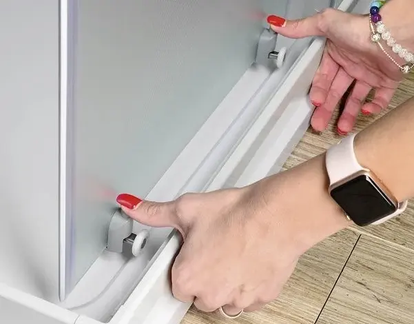 Ruční úprava sprchového koutu při instalaci posuvných dveří.