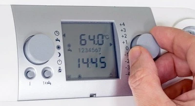 Ruční nastavení pokojového termostatu pro regulaci teploty vytápění.