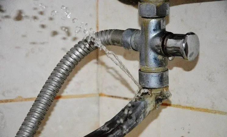 Únik vody z poškozeného ventilu sprchové baterie v koupelně.
