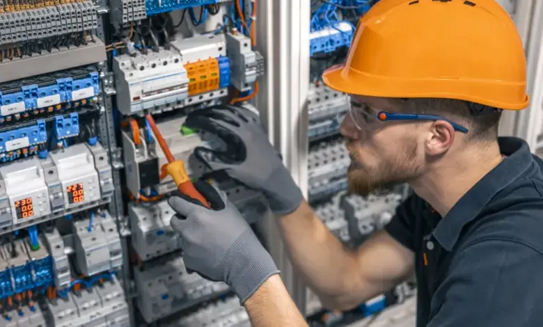 Elektrikář pracuje na rozvaděči s pohybovým senzorem.