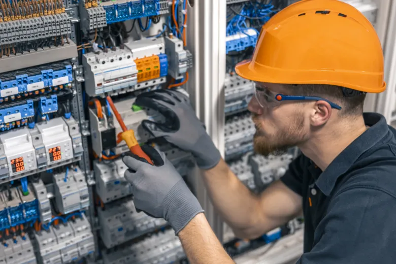 Elektrikář pracuje na rozvaděči s pohybovým senzorem.
