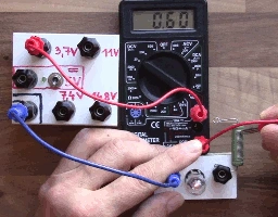 Multimetr měří napětí na elektronickém obvodu s rezistory.