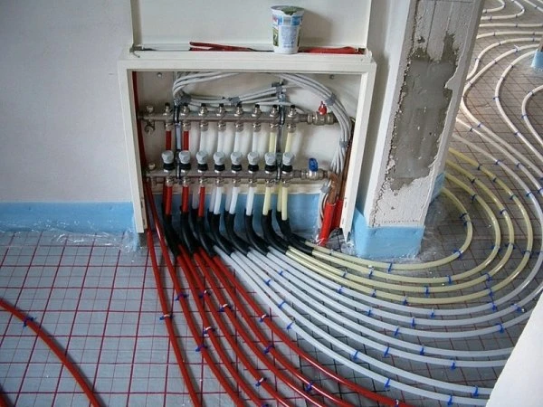 Instalace podlahového vytápění s červenými a bílými trubkami