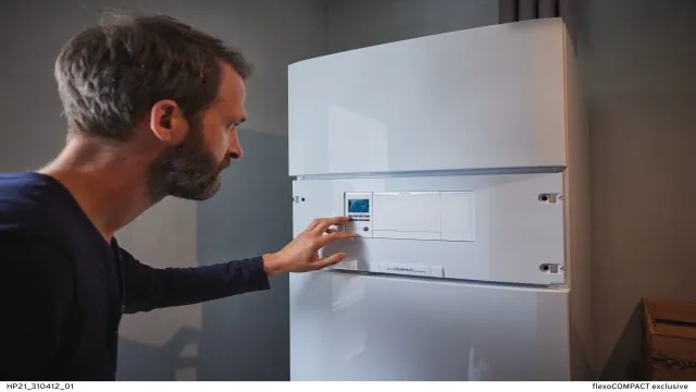 Man adjusting heating control panel
