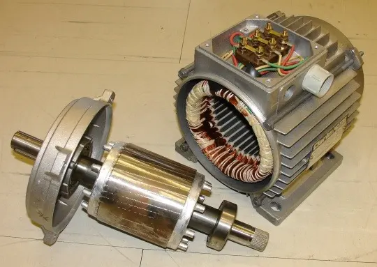 Rozložený třífázový elektromotor s viditelnými cívkami a rotorem.