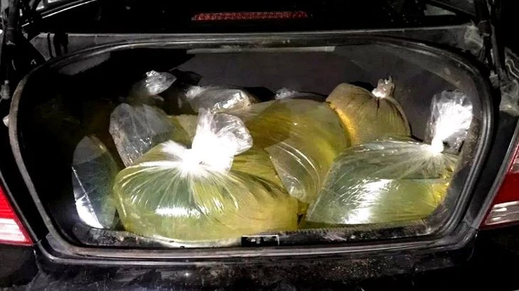 Plastové sáčky se žlutou benzínem v kufru auta.