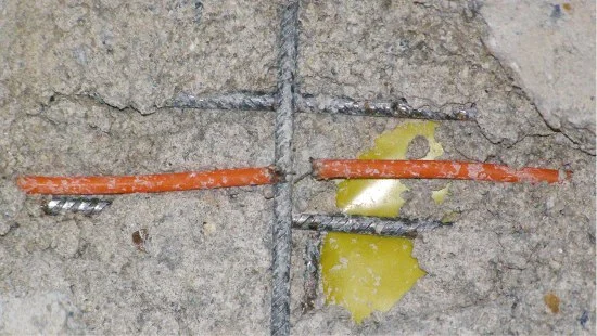 Oranžová kabel pro podlahové vytápění v betonu s výztuží.
