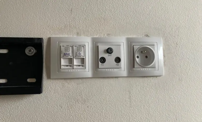 Zdi deska s elektrickými zásuvkami a konektory pro televizní kabely.