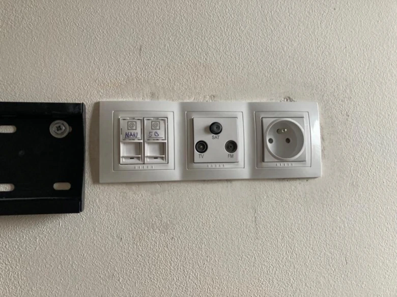 Zdi deska s elektrickými zásuvkami a konektory pro televizní kabely.