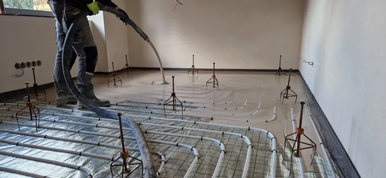 Instalace podlahového topení s trubkami pro vodu.