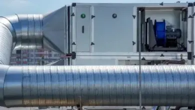 Mechanické větrací zařízení s potrubím na střeše budovy.