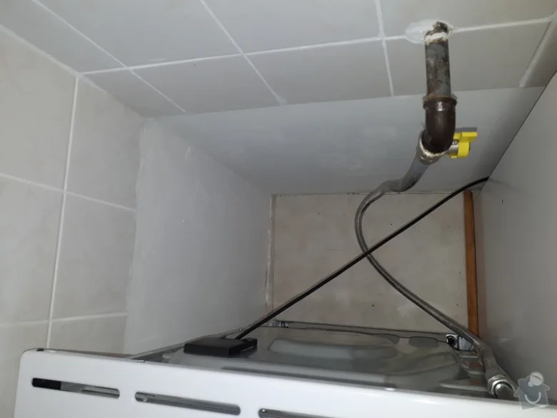Připojení plynového sporáku s hadicemi pod kuchyňskou linkou.