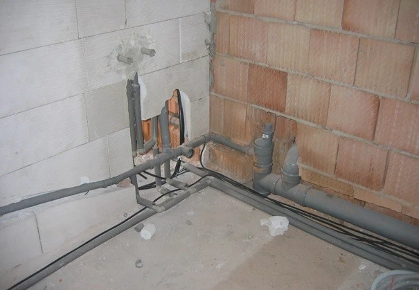 Zobrazení instalace kanalizačních trubek se sklonem pro správný odtok vody.