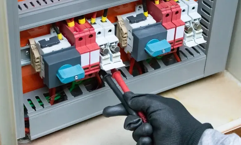 Elektrikář testuje jistič v rozvaděči pomocí napětímetru.