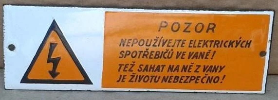 Varovný štítek zakazující používání elektrických spotřebičů ve vaně.