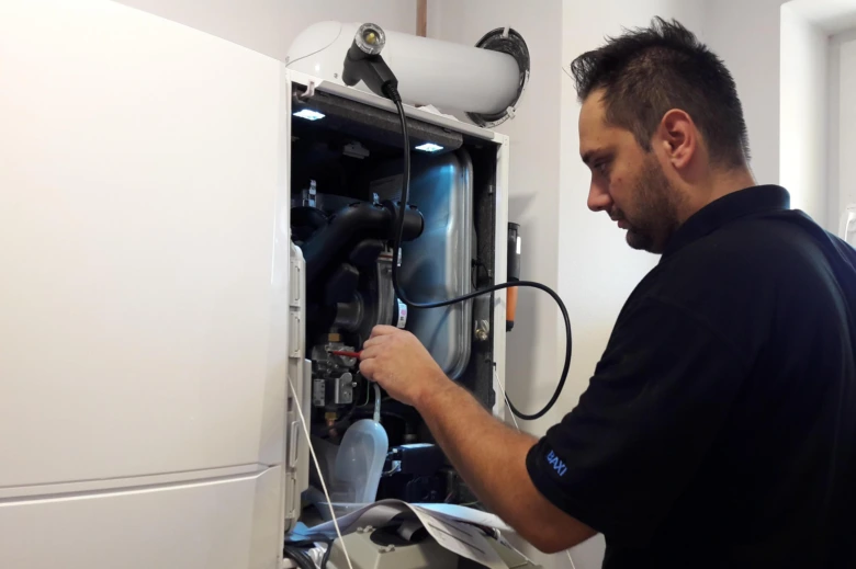 Technik opravuje kotel Baxi v interiéru.