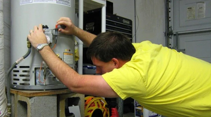 Muž upravuje elektrický kotel pro přepnutí na ohřev teplé užitkové vody.