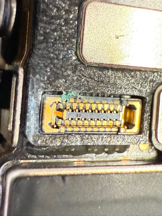 Zkorozený konektor uvnitř telefonu po vniknutí vody.