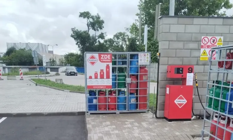 Venkovní skladování plynových lahví v ohradě s doplňovacím zařízením.