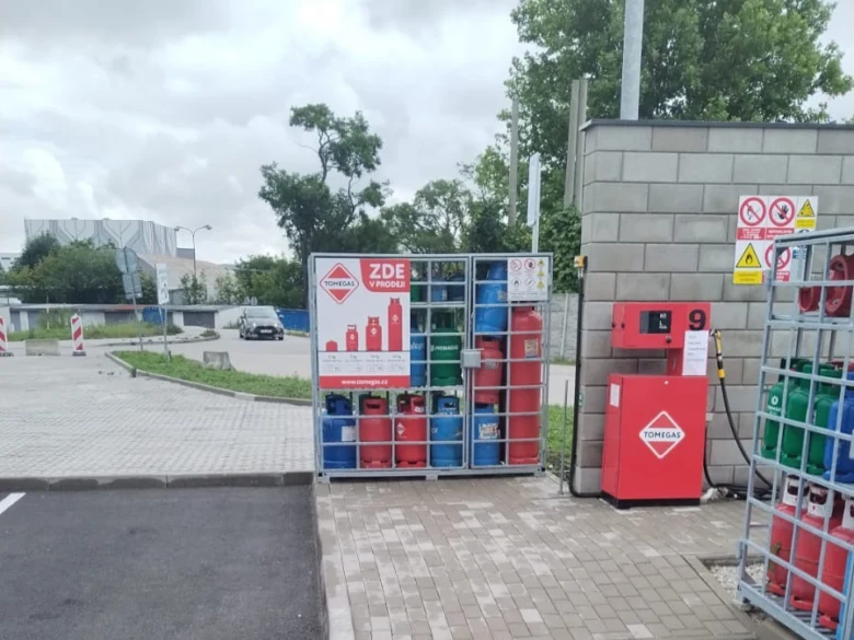 Venkovní skladování plynových lahví v ohradě s doplňovacím zařízením.