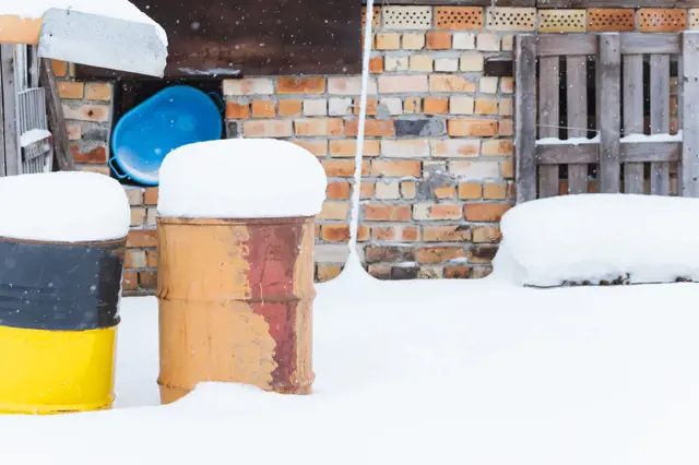 Snow-covered barrels and bins