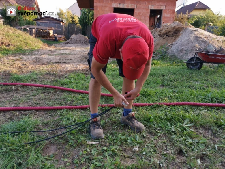 Montáž vodovodního potrubí s elektrickým kabelem v jednom výkopu.