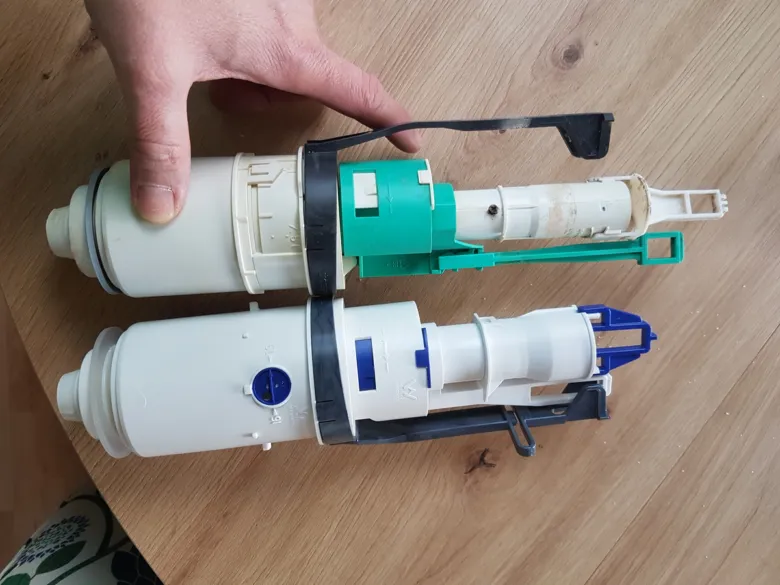 Dva rozložené mechanismy pro splachování v nádržce toalety.