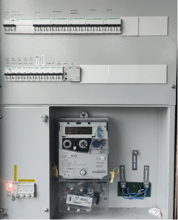 Otevřená elektrická rozvaděč s měřidlem a jističi pro výpočet zátěžového proudu.
