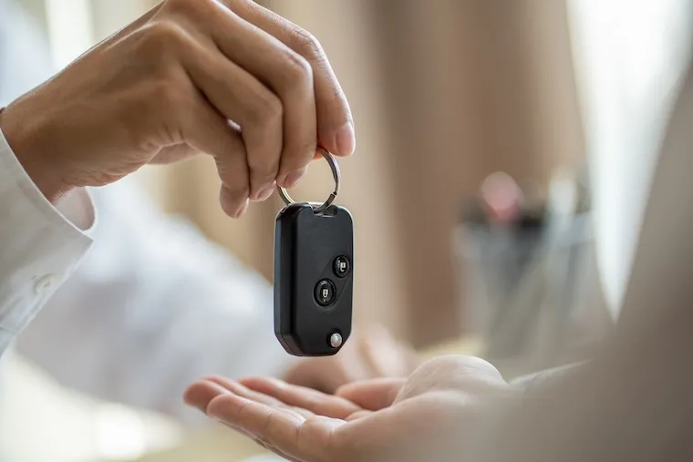 Ruční předání černého dálkového ovladače pro auto.
