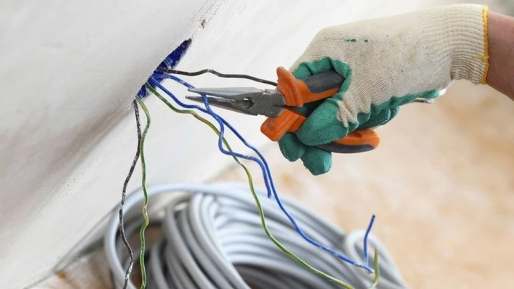 Hand cutting electrical wires with pliers