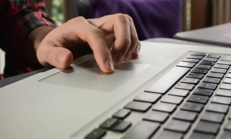 Ruka používá touchpad na notebooku pro ovládání.
