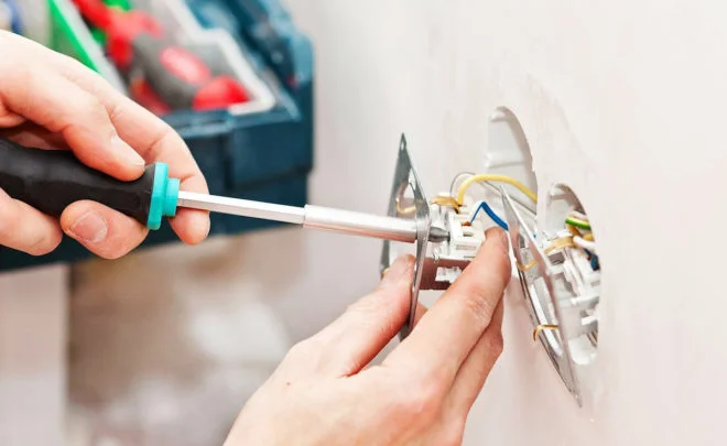 Ruční instalace elektrické zásuvky s odhalenými vodiči