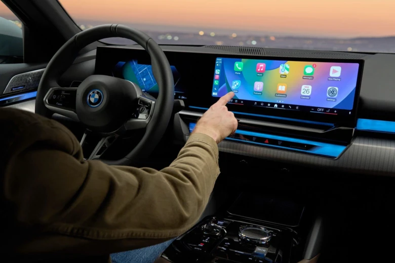 Ruka ovládá displej s aplikacemi v autě s systémem Apple CarPlay.