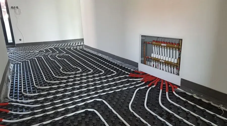 Instalace podlahového topení s rozdělovacím ventilem Valtek v místnosti.