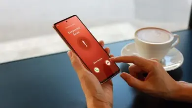 Ruka drží telefon s upozorněním na podezřelý spamový hovor.