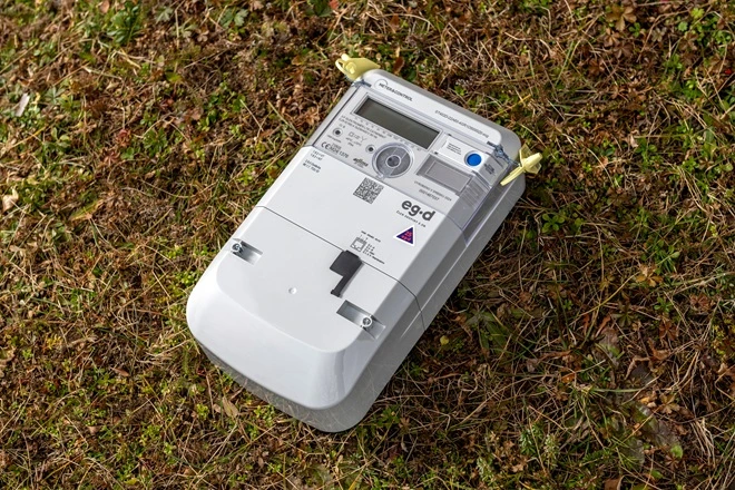 Chytrý elektroměr leží na trávě pro ukázku správného čtení dat.