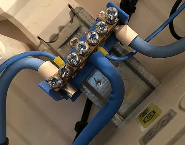 Modré kabely připojené k elektrickému terminálovému bloku pro měření izolačního odporu.