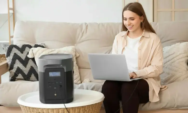 Žena pracuje na notebooku napájeném mobilním zdrojem energie.
