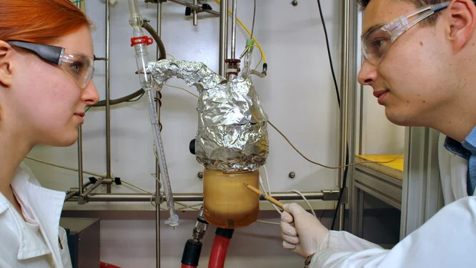 Dva vědci zkoumají zařízení pro tepelný akumulátor v laboratoři.