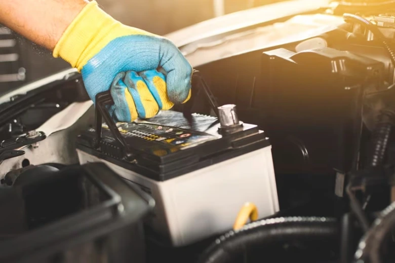 Ruční připojení kabelu k pozitivní svorce automobilové baterie.