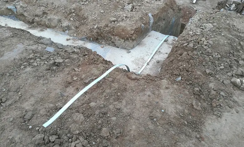 Bílý vodič uzemnění položený v jámě u základové desky.