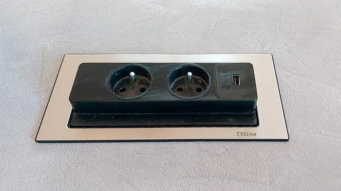 Moderní elektrická zásuvka s dvěma kontakty a integrovaným USB portem.