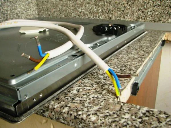Připojení varné desky k elektrické zásuvce s odhalenými vodiči.