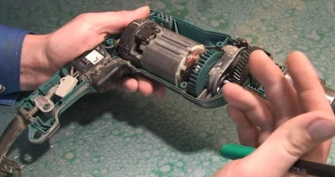 Rozložený elektromotor vrtáku pro kontrolu multimetrem.