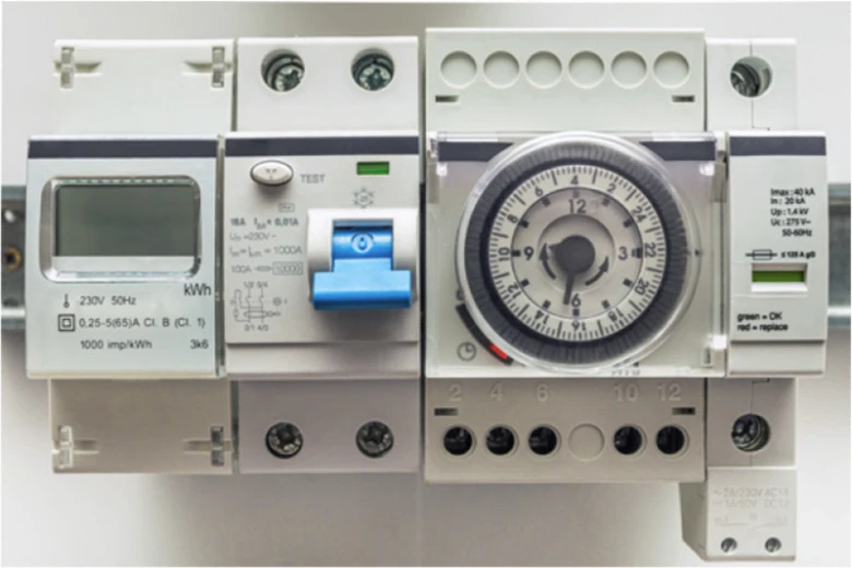 Fotografie průmyslových elektrických relé a měřičů energie.