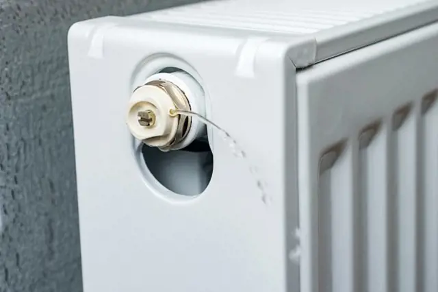 Radiátor s únikem vody z ventilu pro uzavření před zimou.