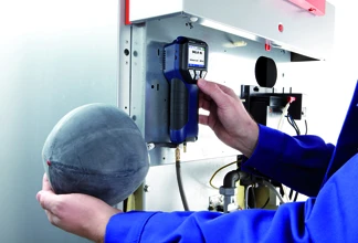 Technik provádí tlakovou zkoušku plynovodu s detektorem plynu.