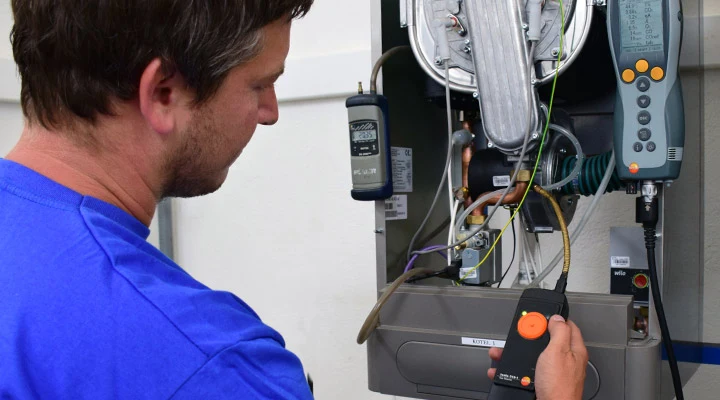 Technik opravuje elektrický kotel pomocí diagnostických nástrojů.
